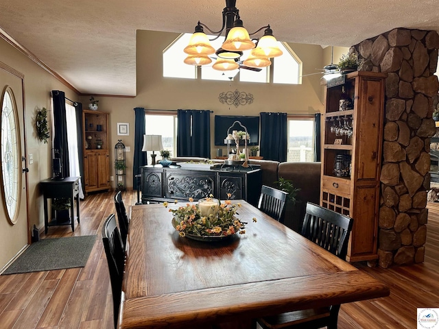 dining room with a textured ceiling, a chandelier, wood finished floors, and ornamental molding