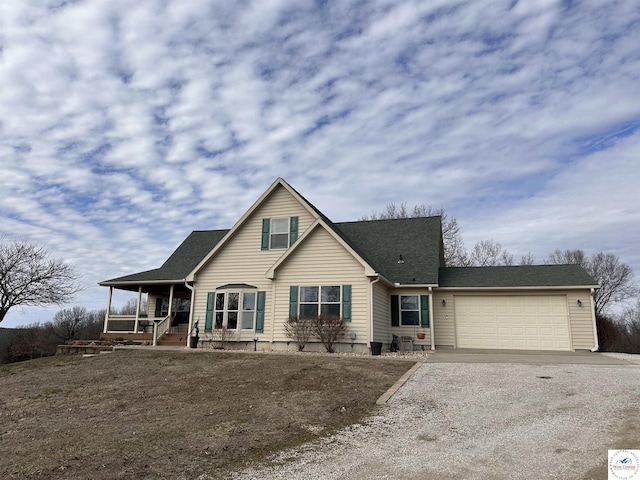 view of front of house with gravel driveway, a garage, a porch, and roof with shingles