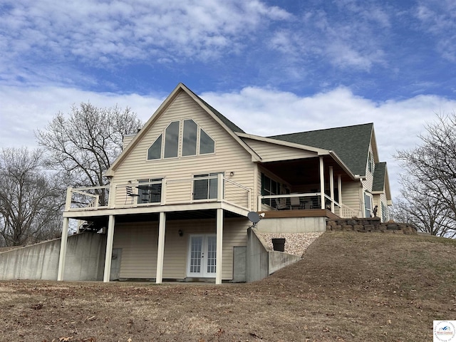 rear view of property featuring french doors and a shingled roof