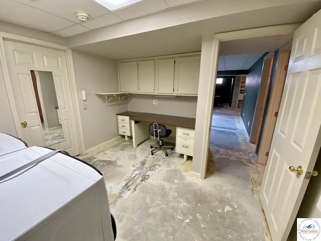 bedroom featuring baseboards, separate washer and dryer, a drop ceiling, and unfinished concrete flooring