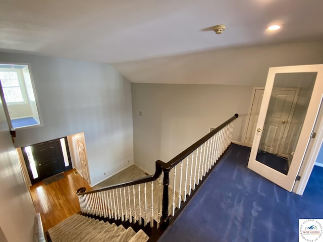 staircase featuring vaulted ceiling and wood finished floors