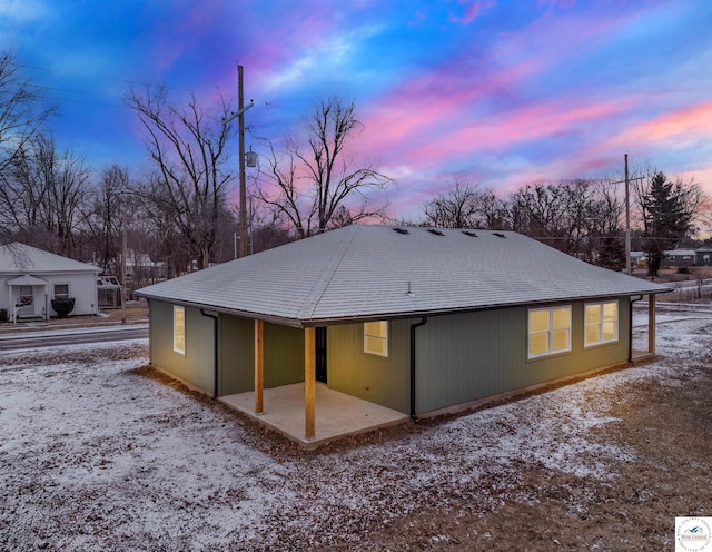 back of property featuring roof with shingles and a patio