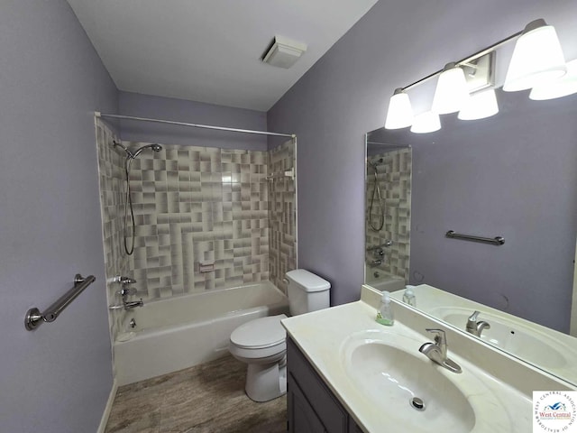 full bathroom with visible vents, toilet, wood finished floors,  shower combination, and vanity