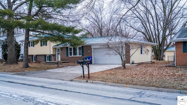 split level home with a garage, driveway, and brick siding