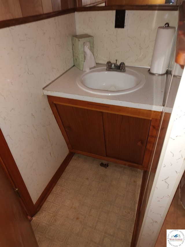 bathroom with wallpapered walls, vanity, baseboards, and tile patterned floors