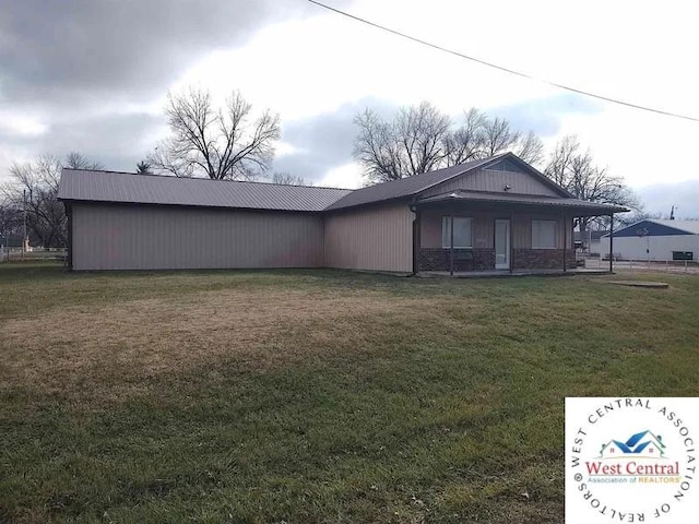 rear view of property featuring a lawn