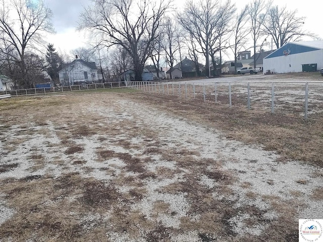 view of yard with fence and a rural view