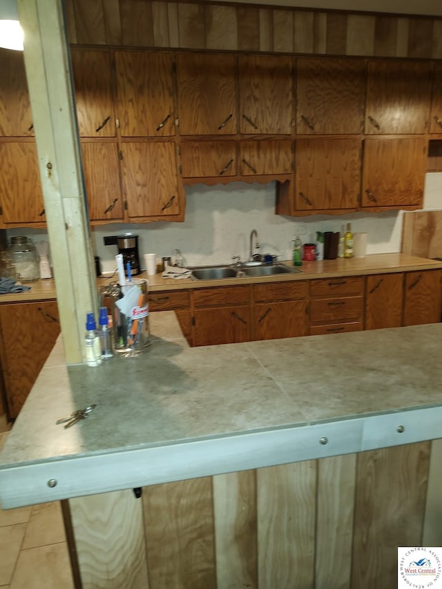 kitchen with brown cabinets, light countertops, and a sink