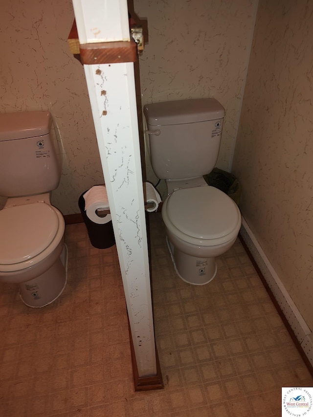 bathroom featuring tile patterned floors, toilet, and wallpapered walls