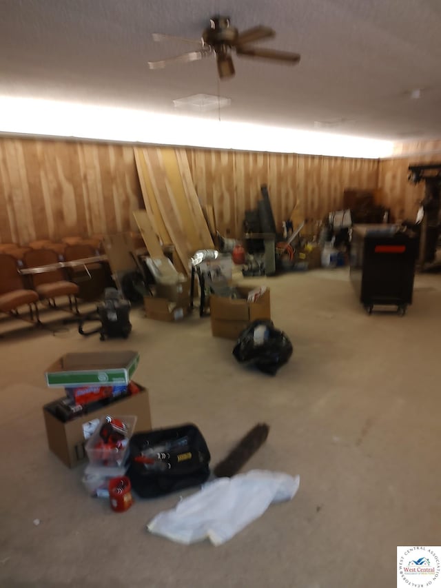 interior space featuring wood walls and ceiling fan