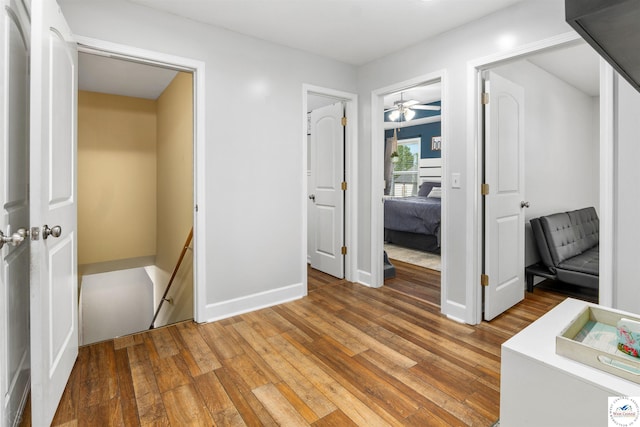 interior space featuring an upstairs landing, baseboards, and light wood-style floors