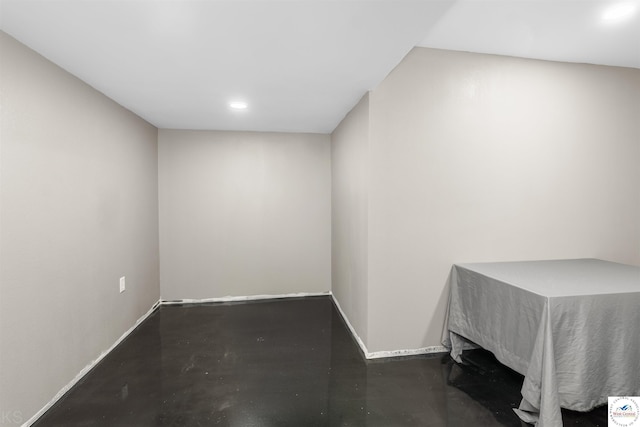 spare room featuring recessed lighting, finished concrete flooring, and baseboards