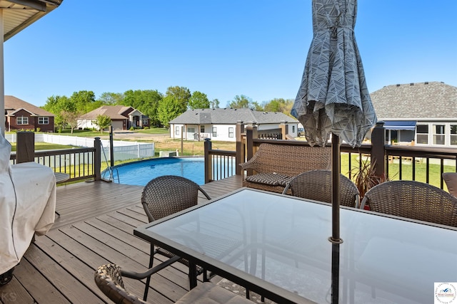 wooden deck with outdoor dining space, a lawn, and a residential view