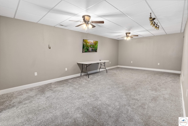 empty room with carpet, visible vents, baseboards, ceiling fan, and a paneled ceiling