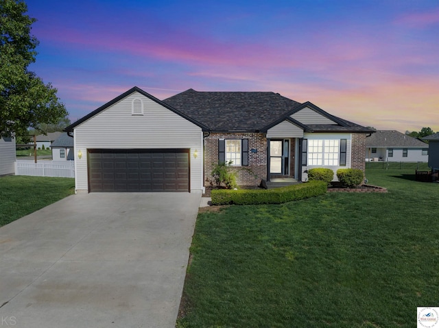 ranch-style home featuring fence, concrete driveway, an attached garage, a front yard, and brick siding