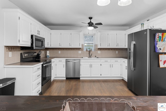 kitchen with a sink, white cabinets, stainless steel appliances, a ceiling fan, and dark wood-style flooring