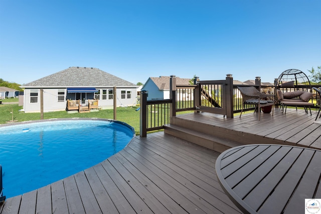 outdoor pool with a deck and a lawn