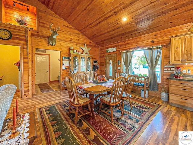 dining room with high vaulted ceiling, wood ceiling, dark wood finished floors, and wood walls