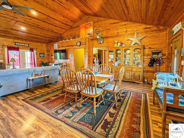 dining space with wood ceiling, ceiling fan, wooden walls, and wood finished floors