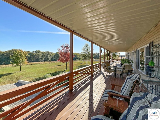 wooden terrace featuring a lawn and outdoor dining space