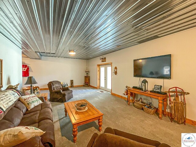 living area featuring french doors, light carpet, and baseboards