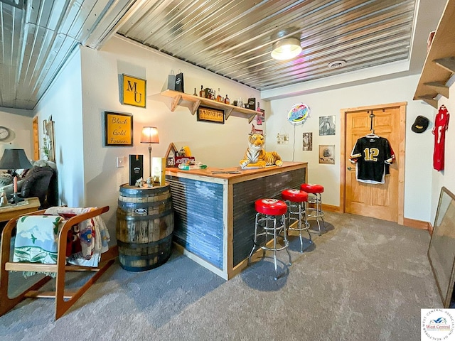 bar with a bar, carpet, wooden ceiling, and baseboards