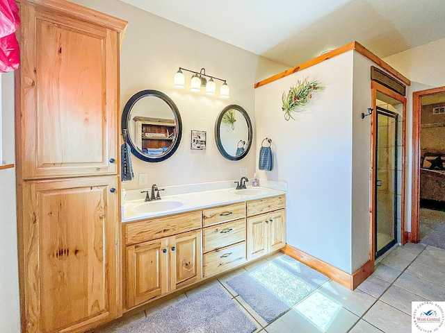 bathroom featuring baseboards, double vanity, a sink, and tile patterned floors