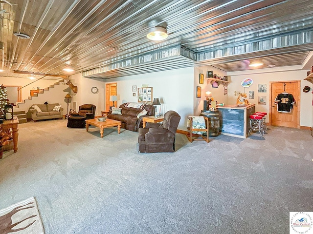 carpeted living room with a dry bar and stairway