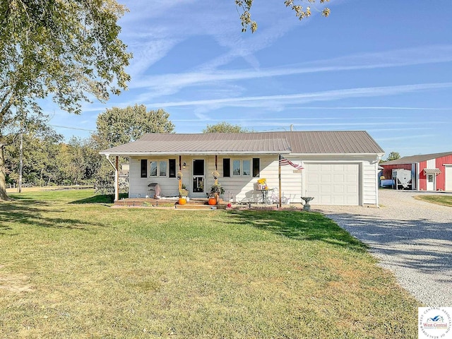 ranch-style home with driveway, metal roof, an attached garage, covered porch, and a front yard