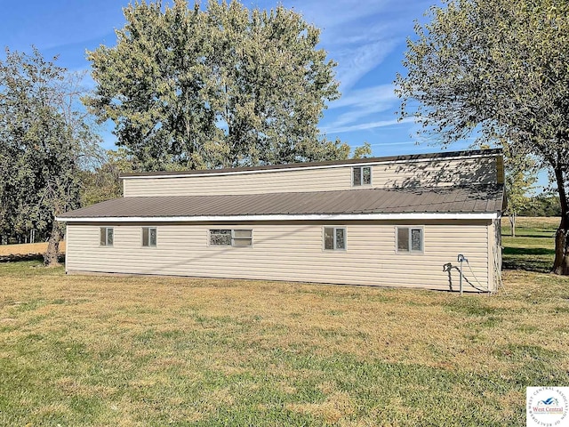 view of property exterior with metal roof and a yard