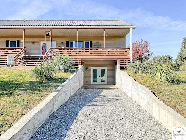 view of front of home with metal roof, french doors, and a front yard