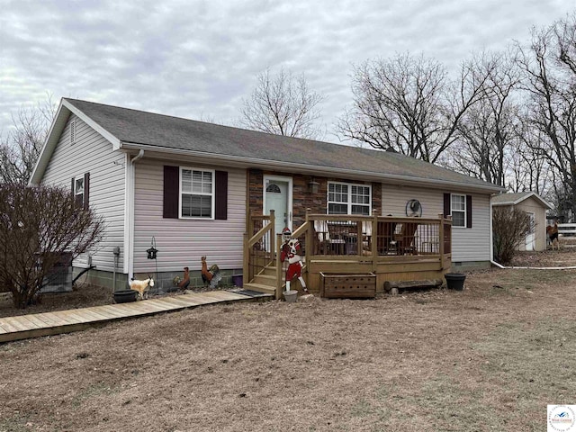 ranch-style home with crawl space, roof with shingles, and a wooden deck