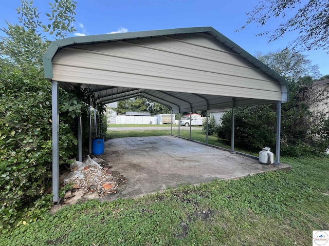 view of parking / parking lot featuring fence and a carport