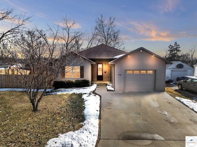 ranch-style home with a garage, driveway, and roof with shingles