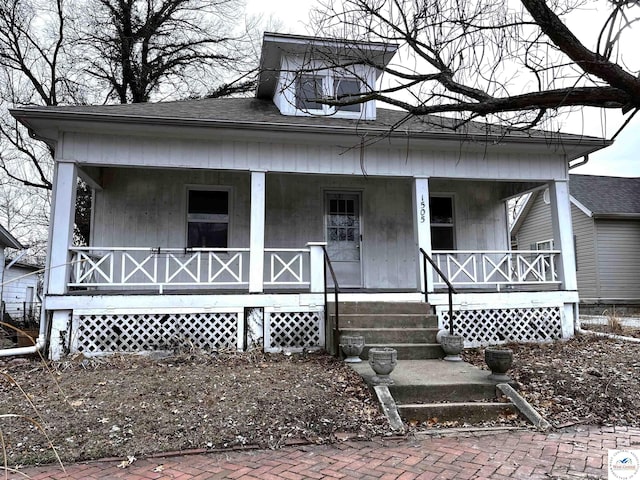 view of front of property with a porch and roof with shingles