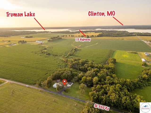 aerial view at dusk with a water view and a rural view