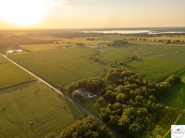 aerial view at dusk with a rural view and a water view