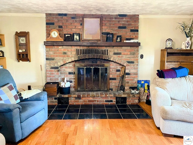 living area featuring a brick fireplace, crown molding, a textured ceiling, and wood finished floors