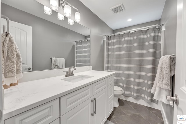 bathroom with toilet, vanity, tile patterned flooring, and visible vents