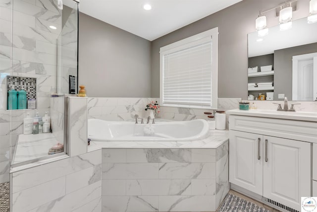 bathroom featuring a stall shower, vanity, and a bath