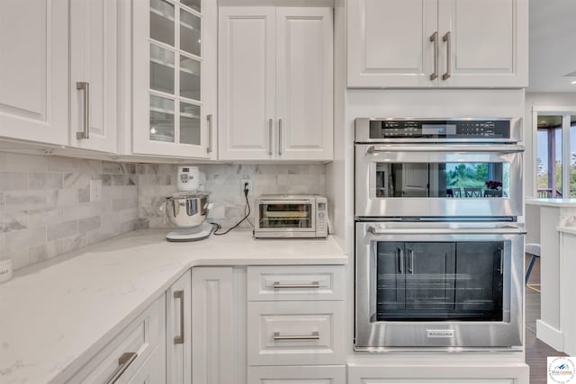 kitchen featuring glass insert cabinets, stainless steel double oven, and white cabinetry