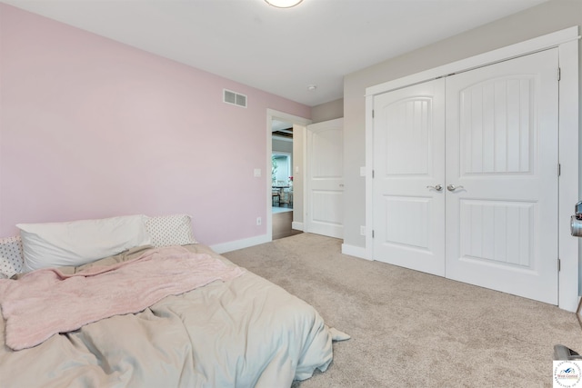 bedroom featuring light colored carpet, a closet, visible vents, and baseboards