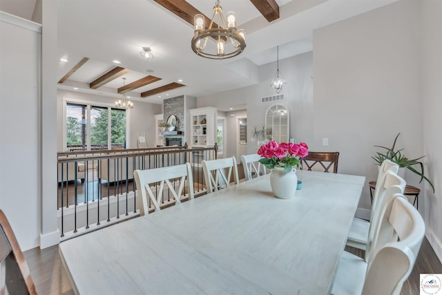 dining space featuring dark wood-style floors, beamed ceiling, and a notable chandelier