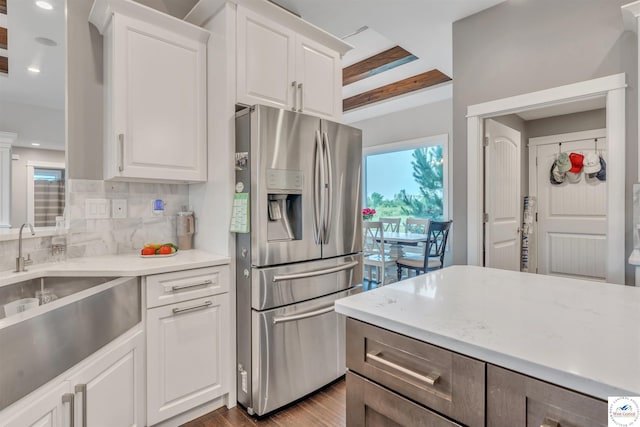 kitchen featuring light wood-style flooring, a sink, white cabinetry, stainless steel refrigerator with ice dispenser, and tasteful backsplash