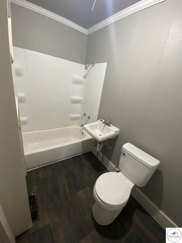 full bathroom featuring bathtub / shower combination, toilet, wood finished floors, baseboards, and crown molding