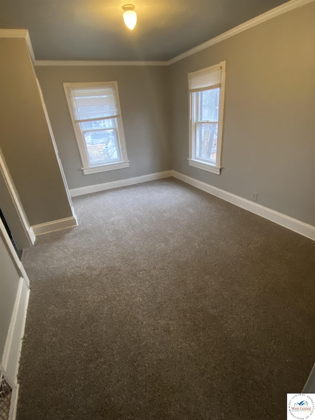 unfurnished room with ornamental molding, dark carpet, and baseboards