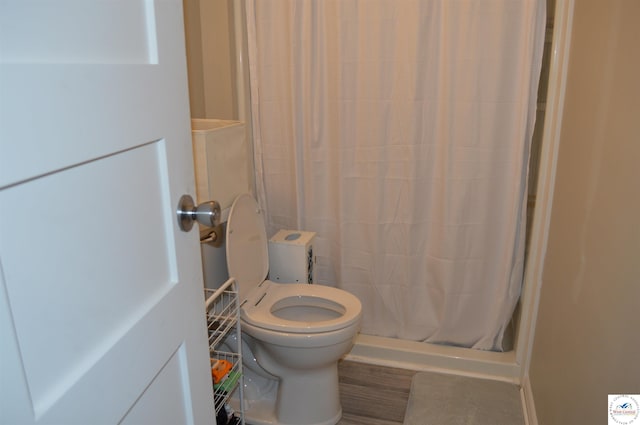 bathroom with a stall shower and toilet