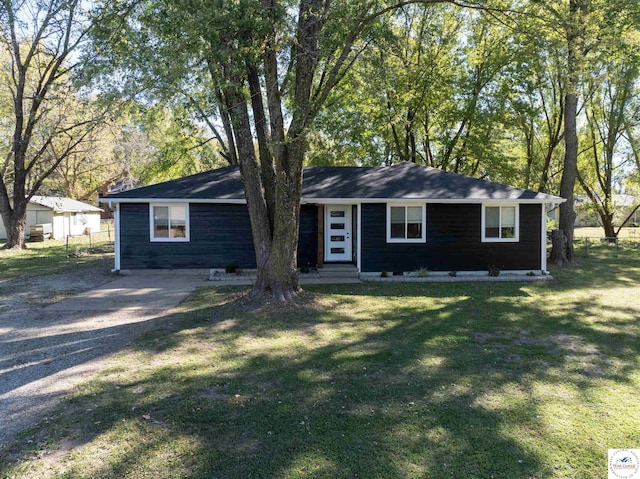 ranch-style house with entry steps, driveway, a front lawn, and fence