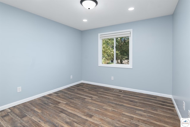 empty room with recessed lighting, dark wood finished floors, visible vents, and baseboards