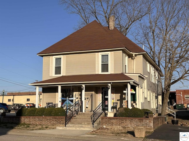 view of front of property featuring a porch and a chimney